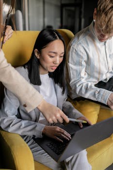 Diverse team collaborating on laptops in a modern office setting.