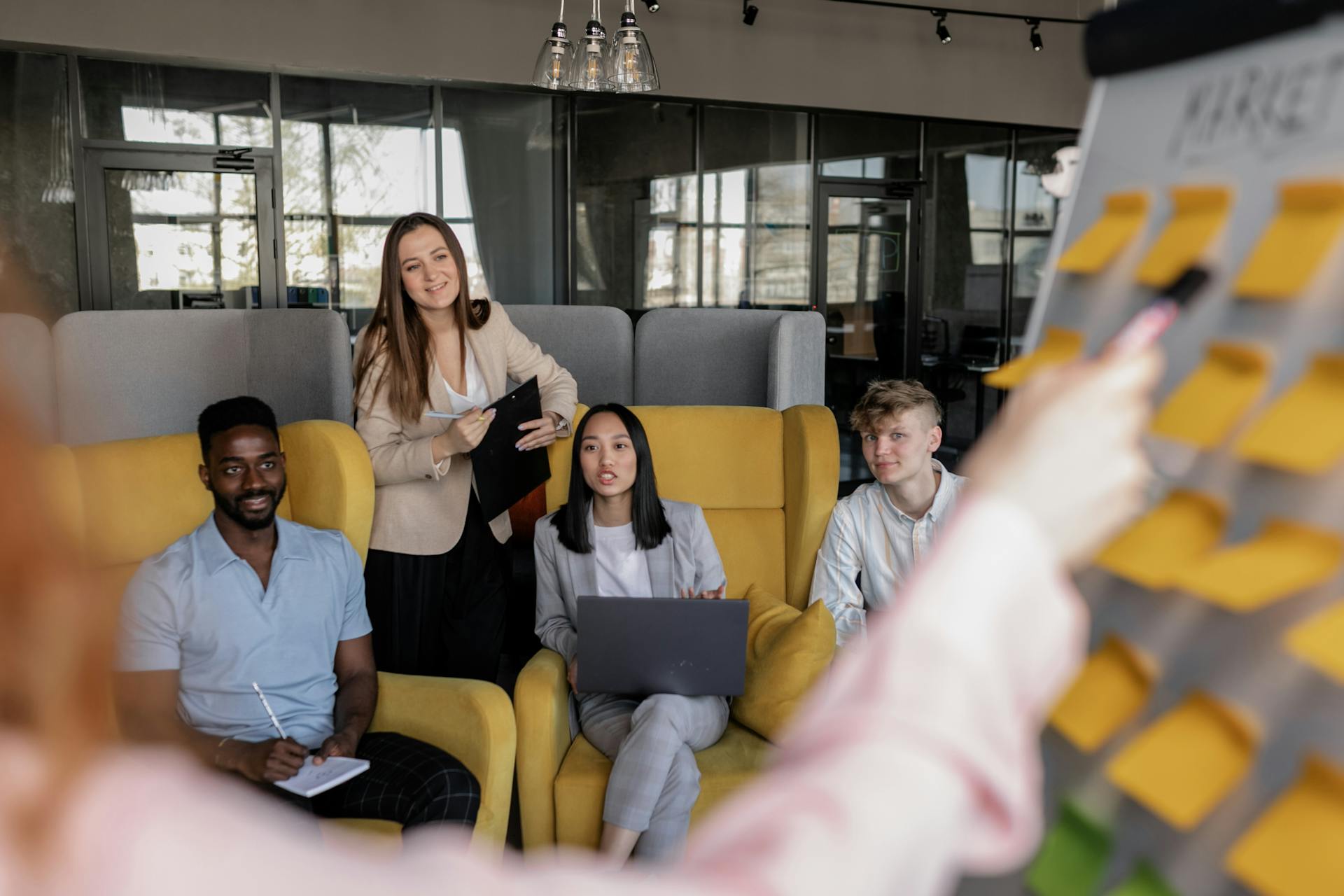 A group of colleagues engaged in a business meeting with sticky notes in a modern workspace.