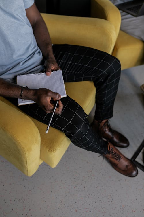 Free Overhead Shot of a Person Holding a Pencil and a Notebook Stock Photo