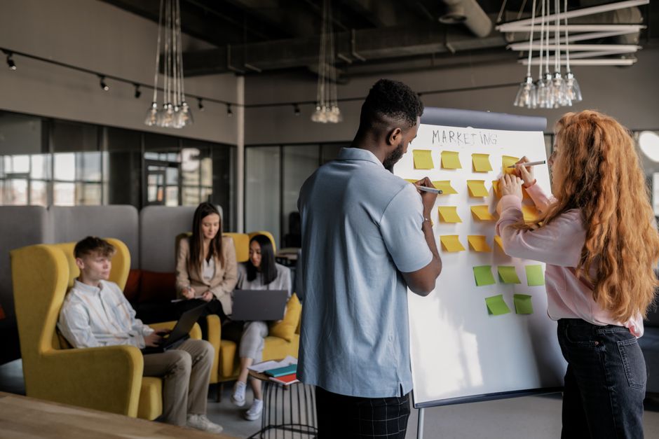 Marketing team planning email strategy around a whiteboard