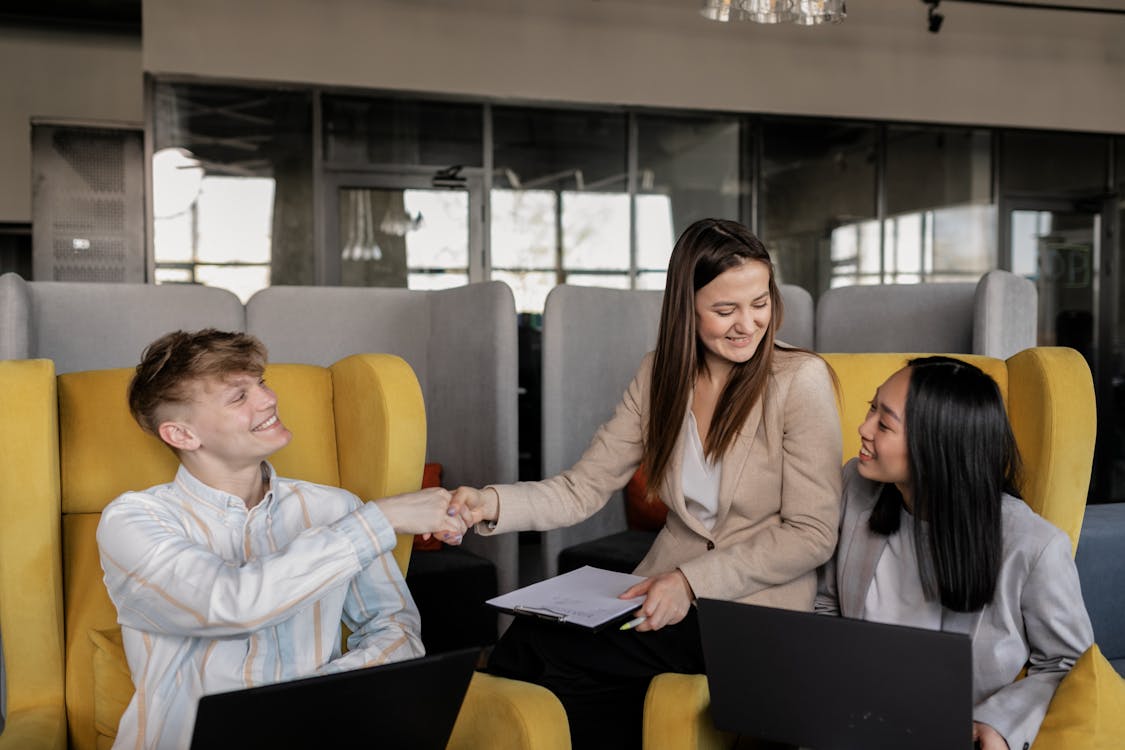 Photo of a Man and a Woman Doing a Handshake while Smiling