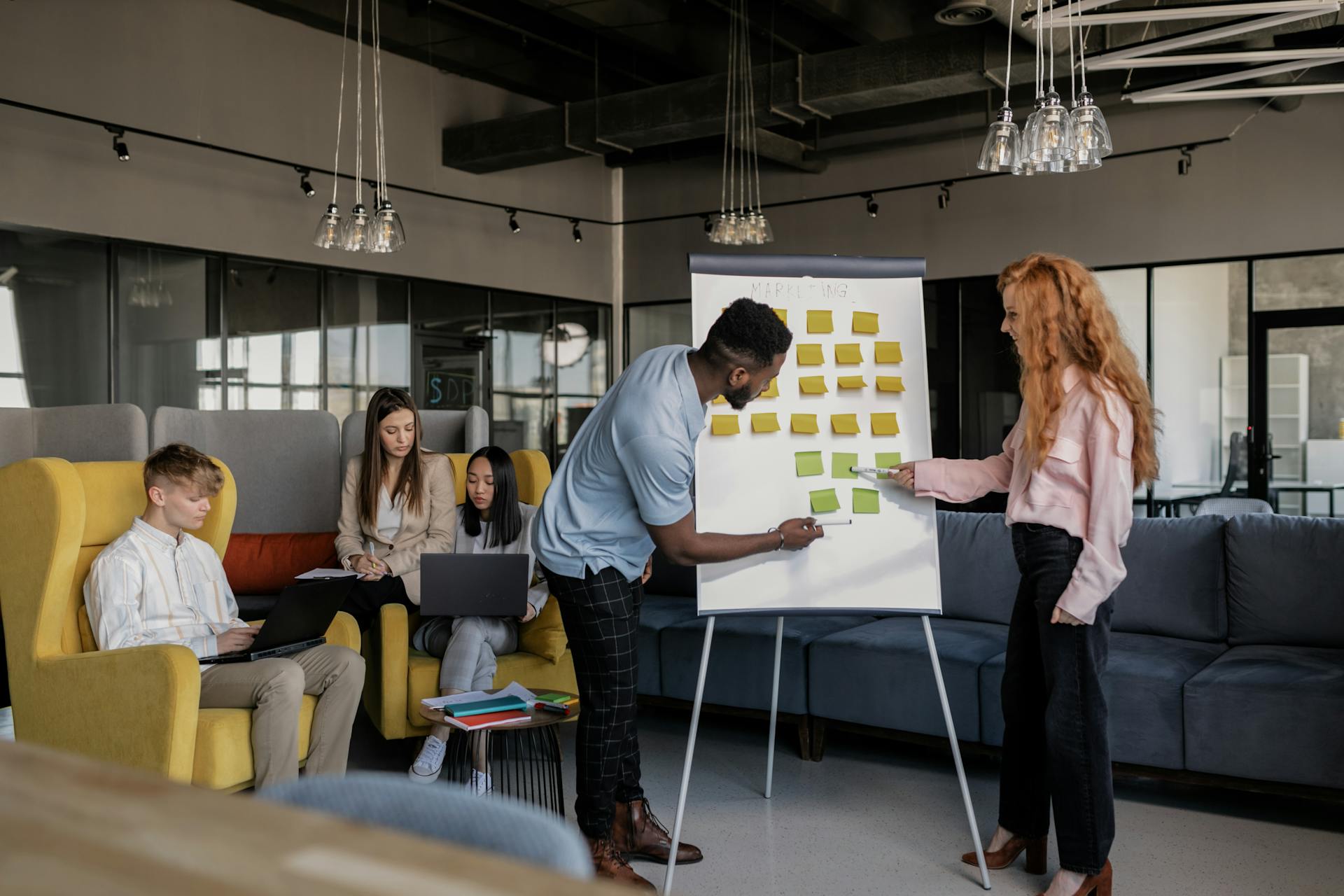 A Man and a Woman Having a Discussion Over a Board with Post Its