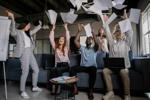 Free Photo of Coworkers Throwing Pieces of Paper Stock Photo