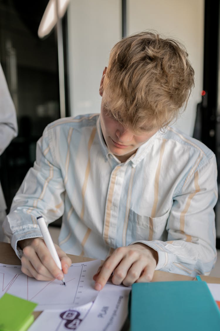 A Man Writing On A White Paper