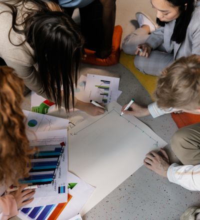Small group working through notes on the floor, photo by Alena Darmel on Pexels