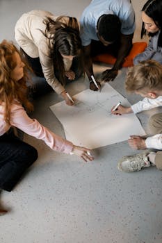 A diverse group of young adults brainstorming and sketching on large sheet paper for strategy planning.