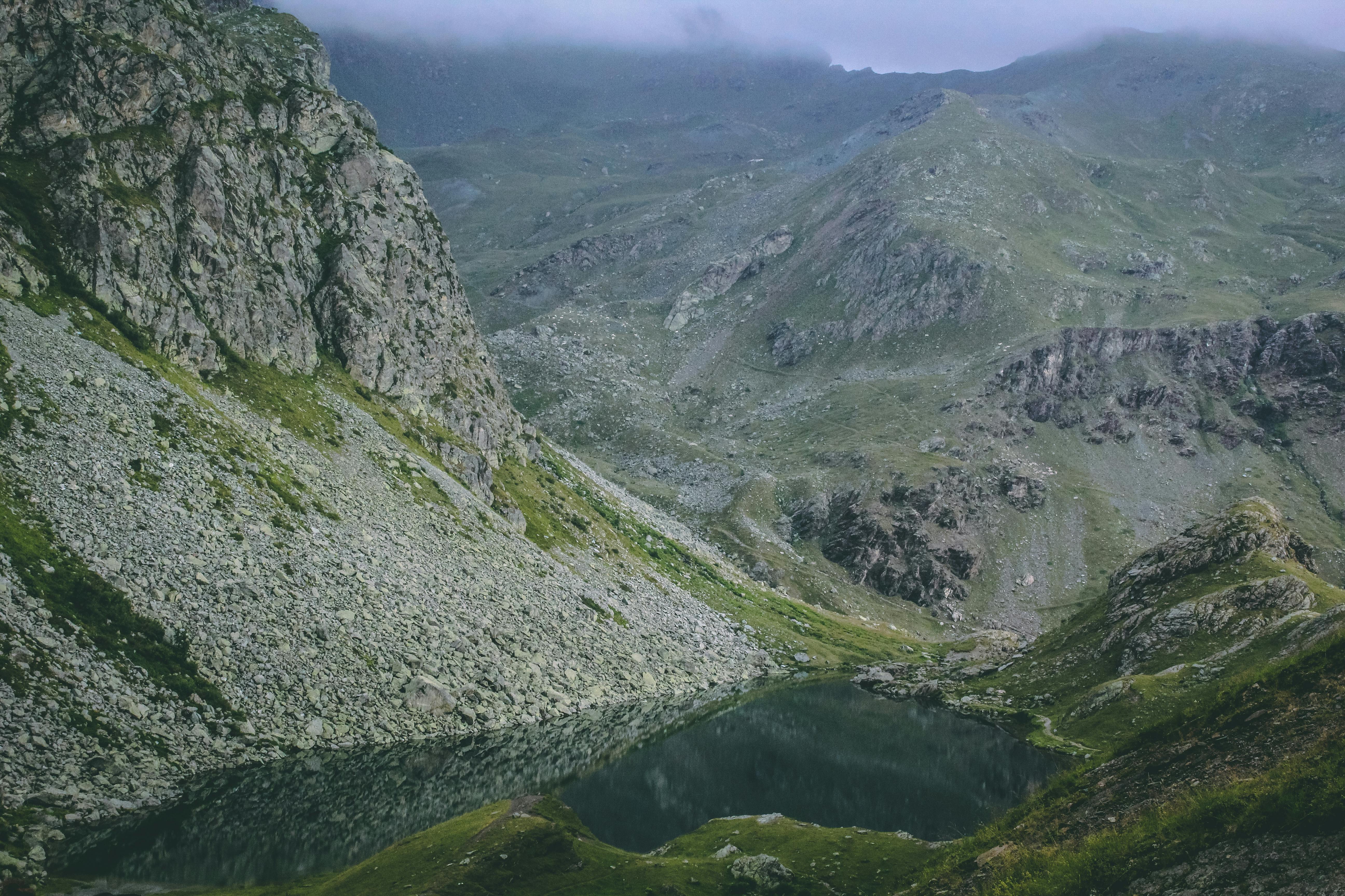 探索令人惊叹的山地景观，这里有宁静的湖泊，四周环绕着岩石地形和郁郁葱葱的绿色植物
