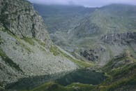 探索令人惊叹的山地景观，这里有宁静的湖泊，四周环绕着岩石地形和郁郁葱葱的绿色植物