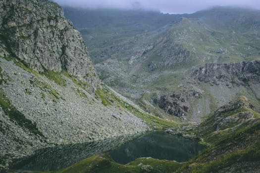 探索令人惊叹的山地景观，这里有宁静的湖泊，四周环绕着岩石地形和郁郁葱葱的绿色植物