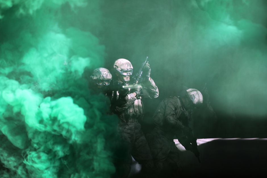 United States Army soldiers moving through a smoke-filled combat zone United States Army soldiers moving through a smoke-filled combat zone