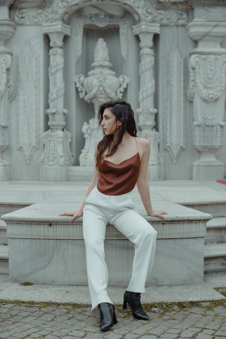 Woman Leaning On Marble Surface Near Bas Relief