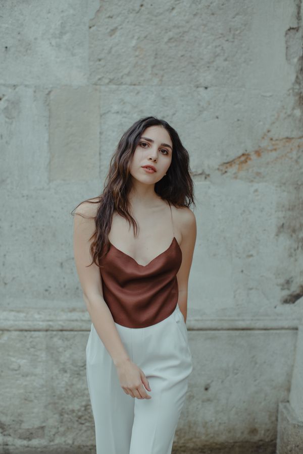 Woman wearing a satin skirt with a knit top in the daytime