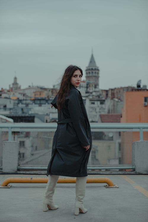 Free Woman in boots and coat with Galata Tower backdrop, cityscape view. Stock Photo