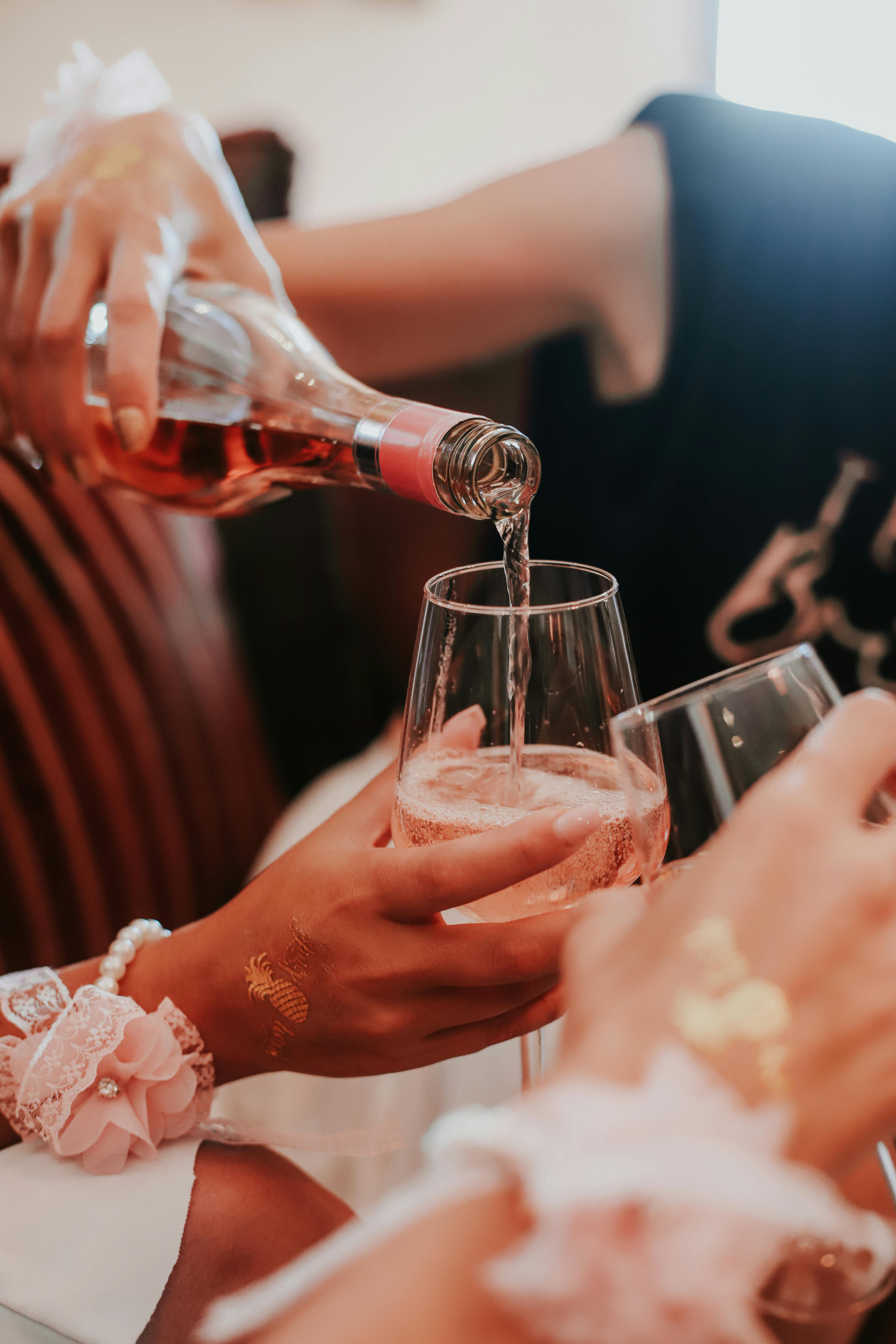 crop female best friends drinking wine before wedding ceremony