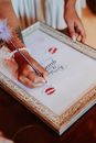 Crop lady writing on framed picture during bridal shower