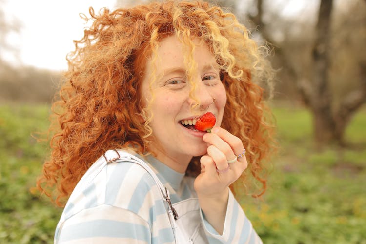 A Woman Eating A Strawberry