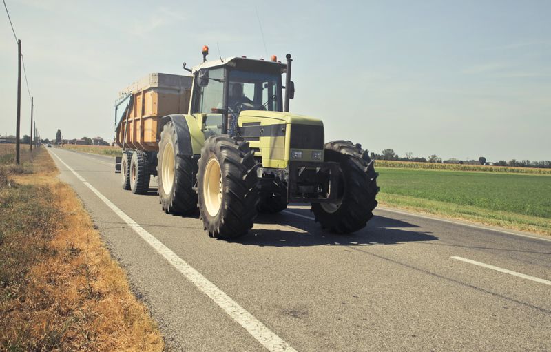Yellow heavy tractor parked on a works road