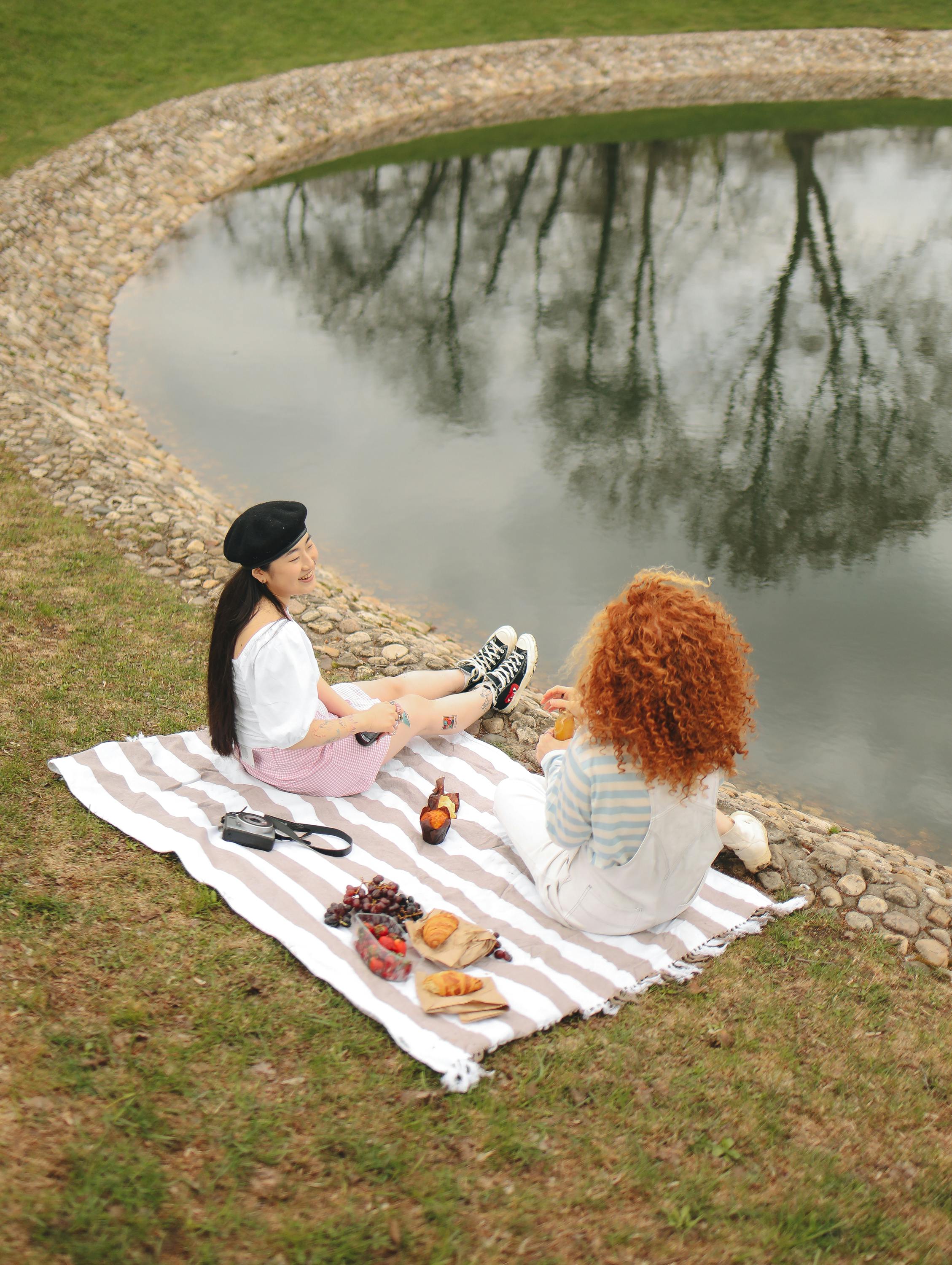 women having picnic near pond