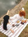 Woman in White Long Sleeve Shirt Sitting on White and Brown Textile