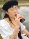 Woman in White Shirt Drinking from Bottle