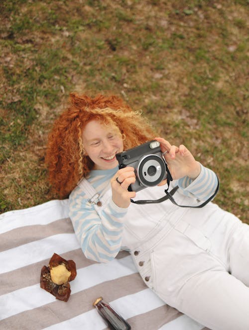 Girl with Red Curly Hair Holding a Camera