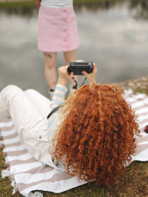 Woman in White Long Sleeve Shirt Holding Black Camera