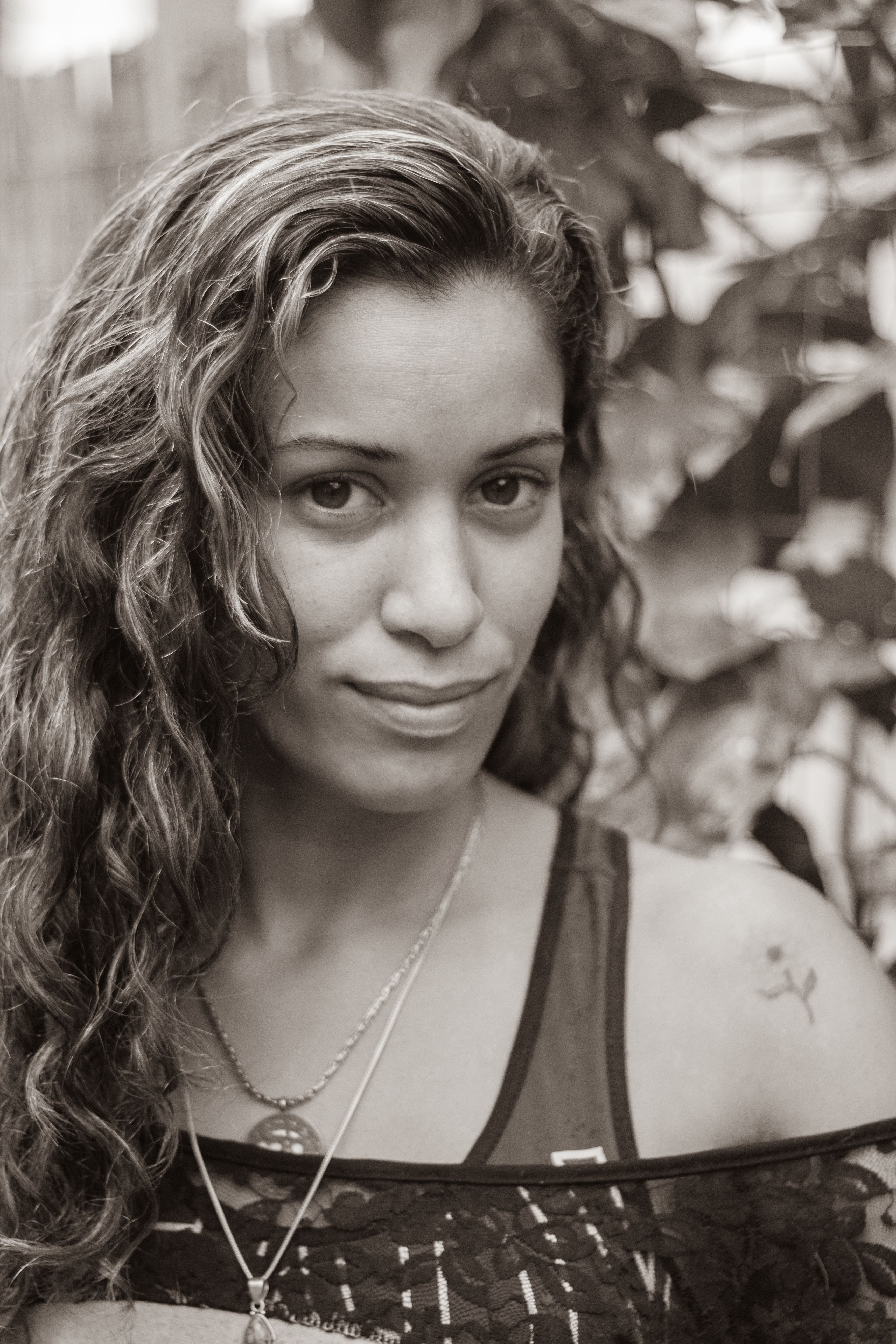 A Woman with Curly Hair Smiling at the Camera · Free Stock Photo