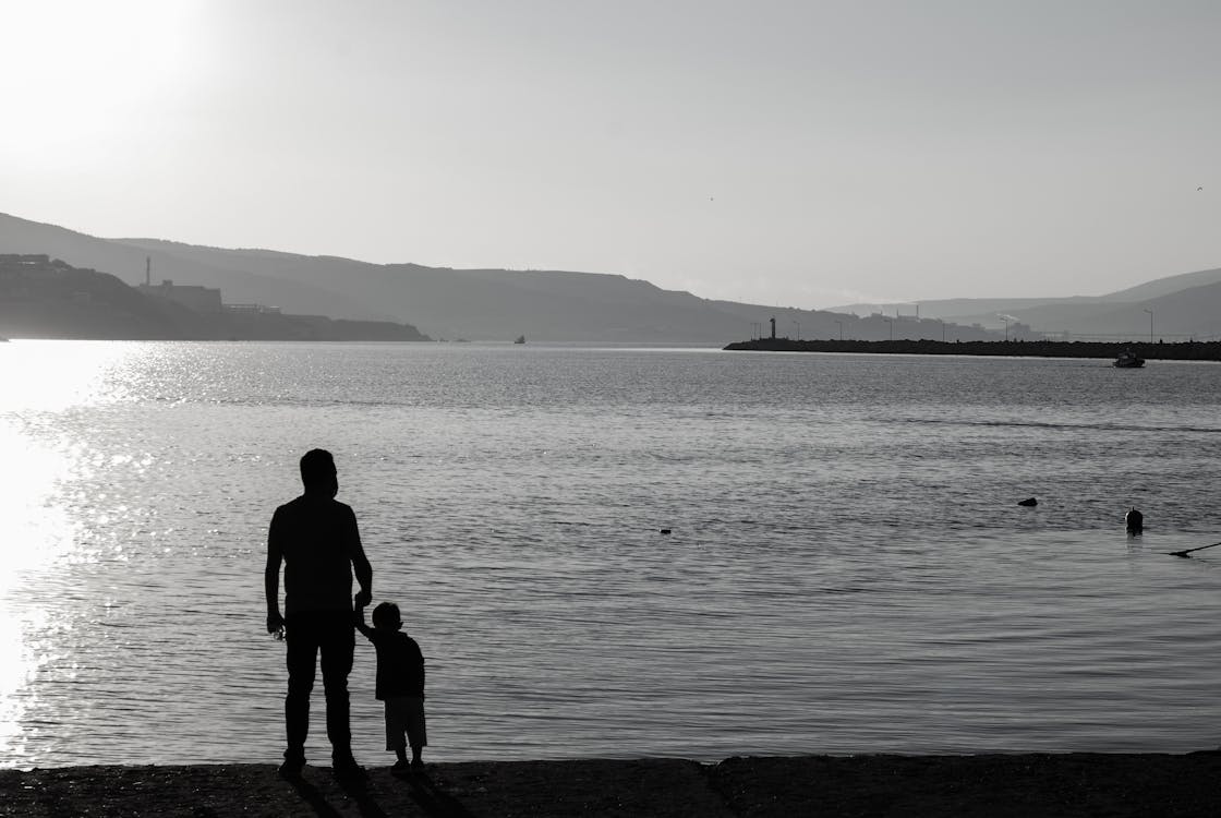 Fotos de stock gratuitas de foto en blanco y negro, padre e hijo, pantalones tejanos azules