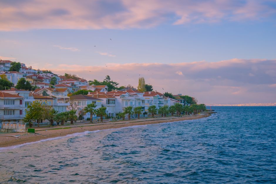 Picturesque coastal town in Turkey with houses lining the sea during a serene sunset.