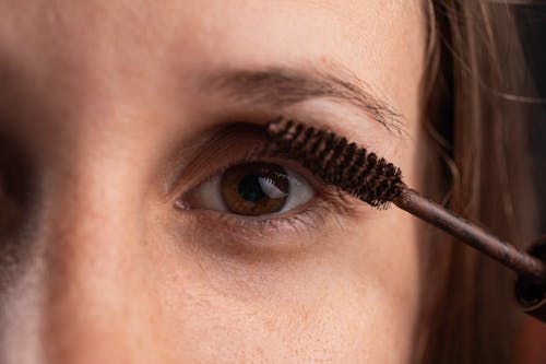 A Close-Up Shot of a Person Applying a Mascara Makeup
