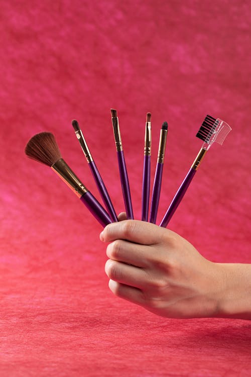 A Hand Holding Make-up Brushes 