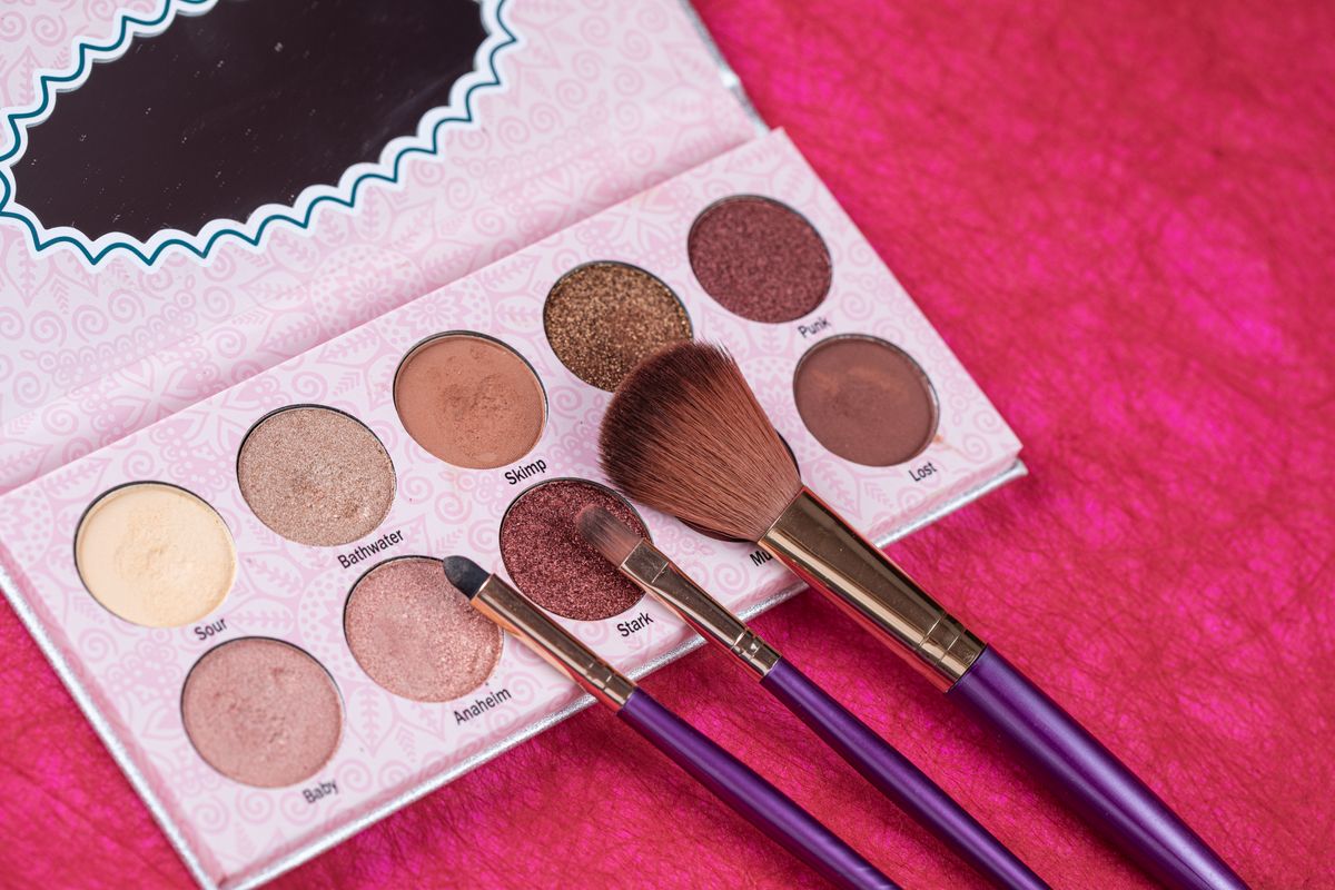 Pink eyeshadow palette and makeup brushes