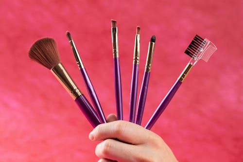 A Person Holding Makeup Brushes