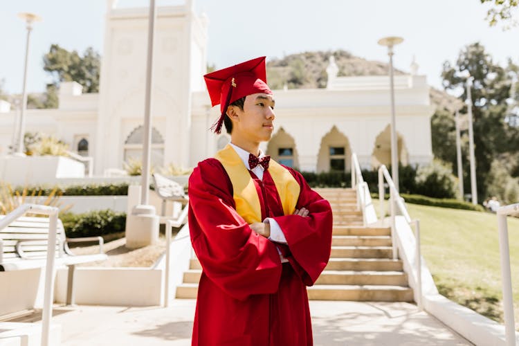 Man Wearing Red Graduation Gown And Cap