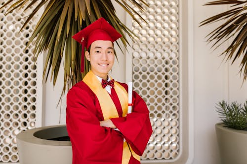 Free Man in Red Graduation Gown Posing Stock Photo