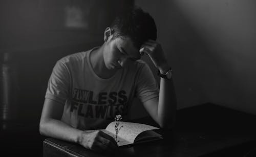 Free Grayscale Photography of Man in Shirt Reading Notebook Stock Photo