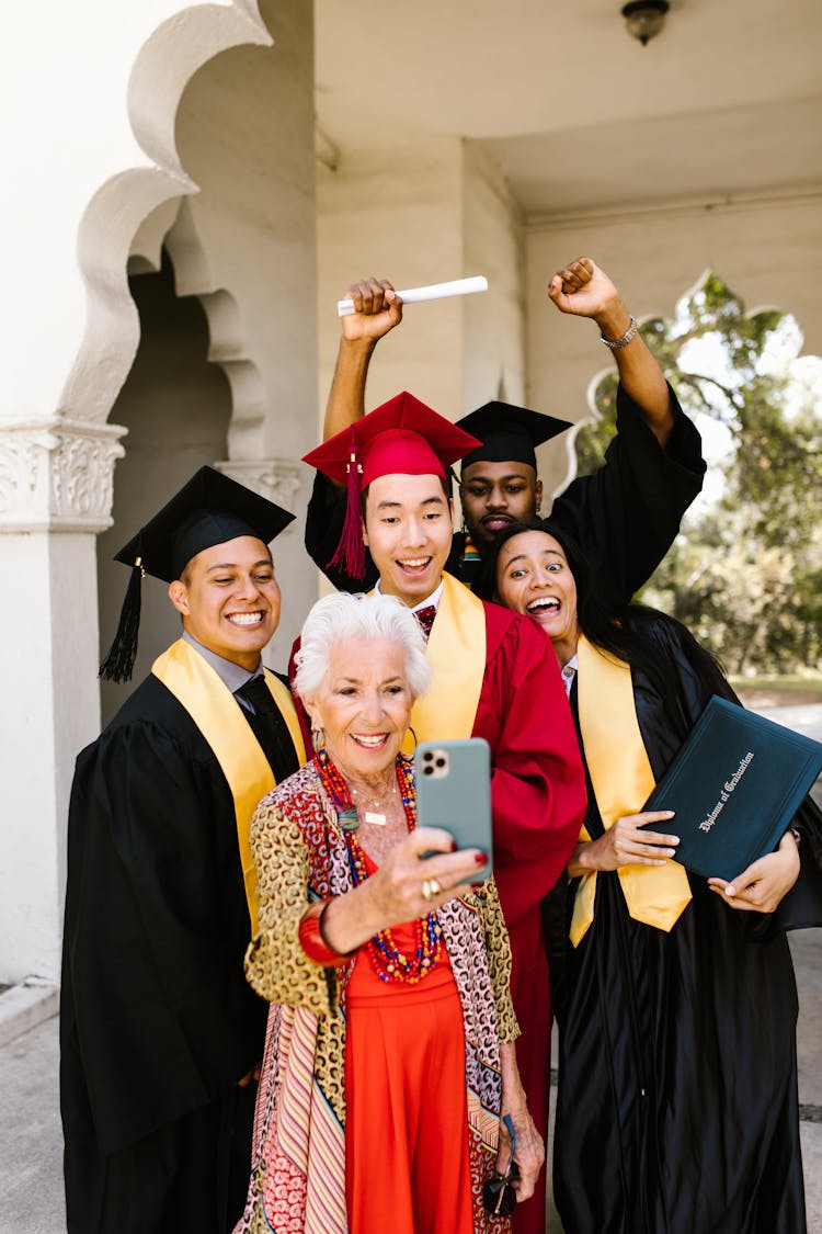 An Elderly Woman Taking A Groupie With The Graduates