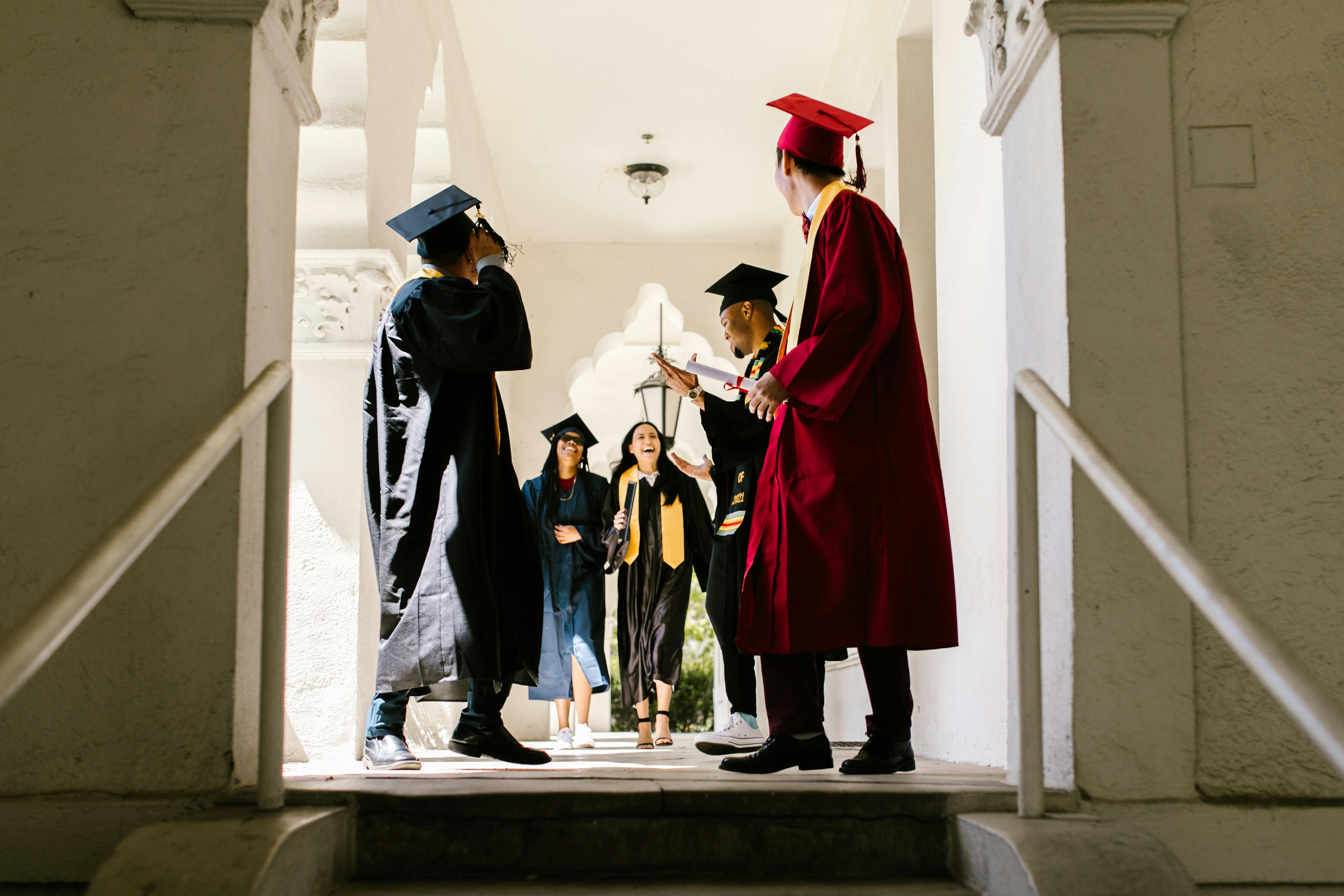Free Graduating Students Walking Down the University Hallway Stock Photo