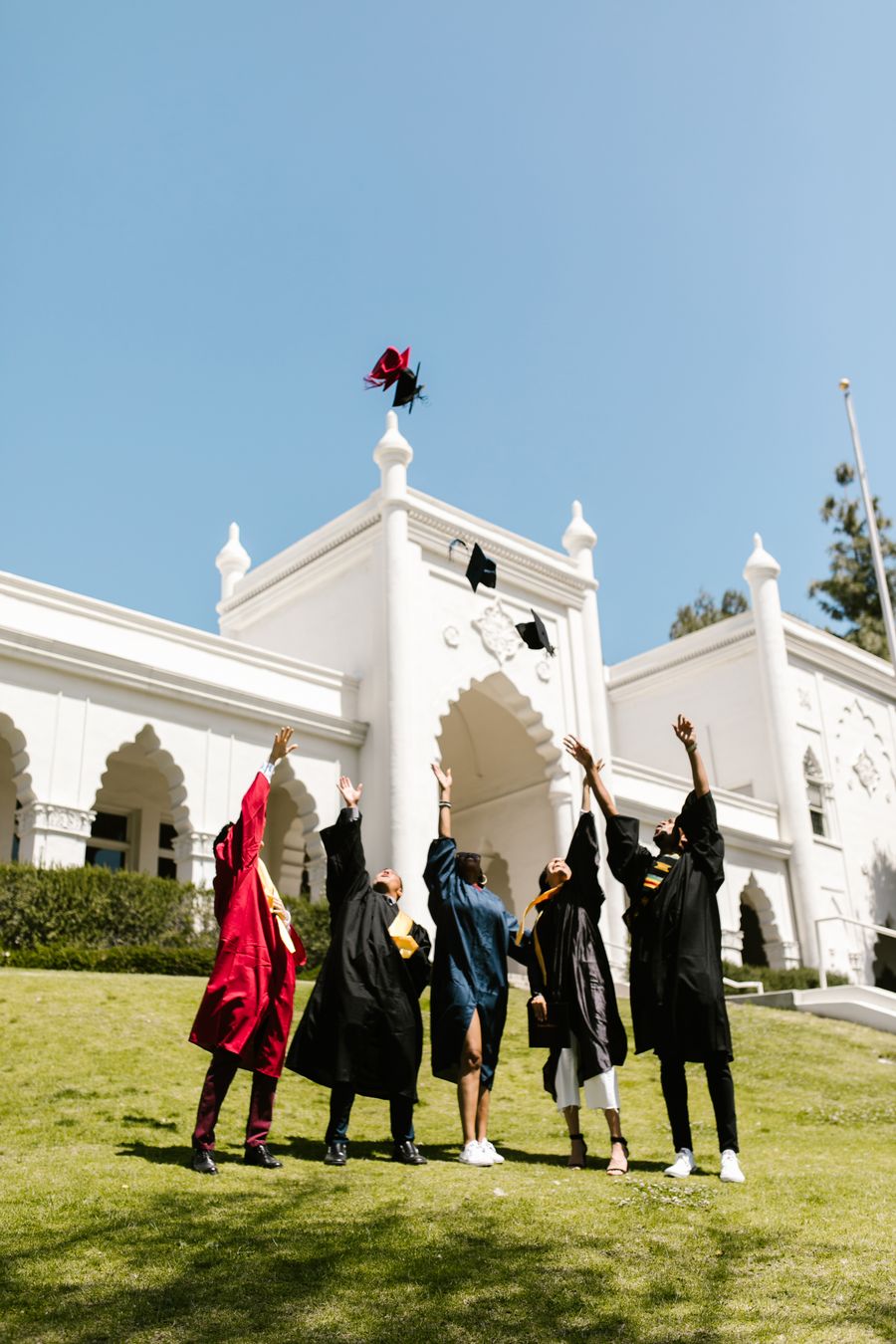 Graduates celebrating with a cap toss outside the convocation hall