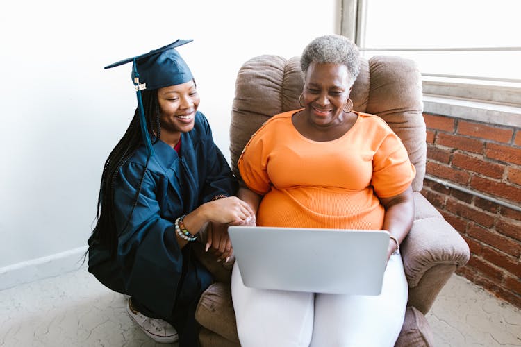 Women Using A Laptop During Virtual Ceremony