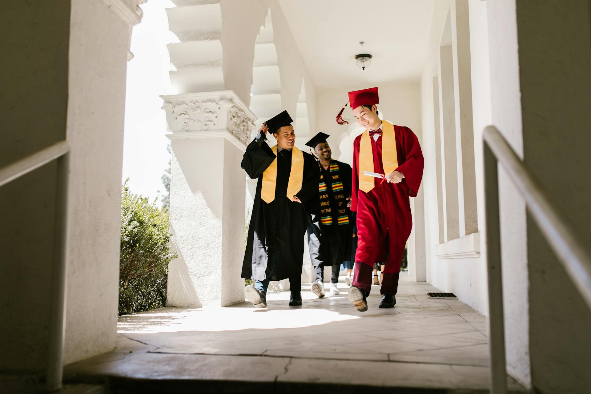 Excited graduates in caps and gowns celebrate after a university ceremony.