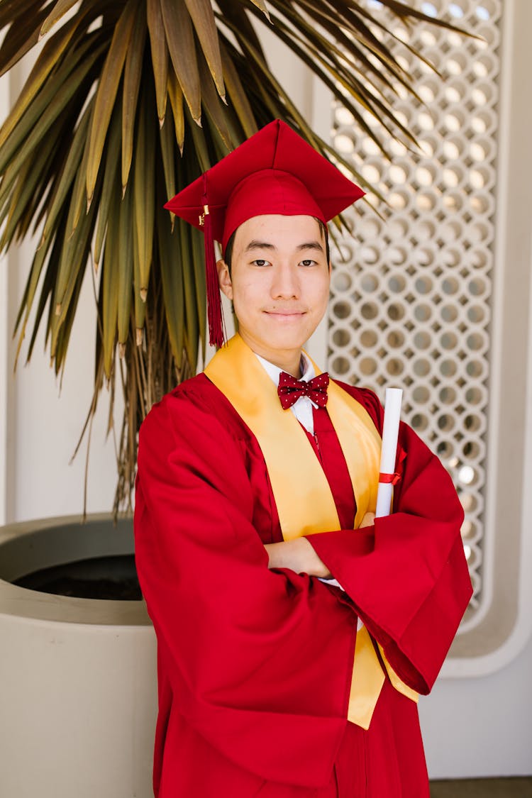 A Fresh Graduate Man In Red Academic Gown