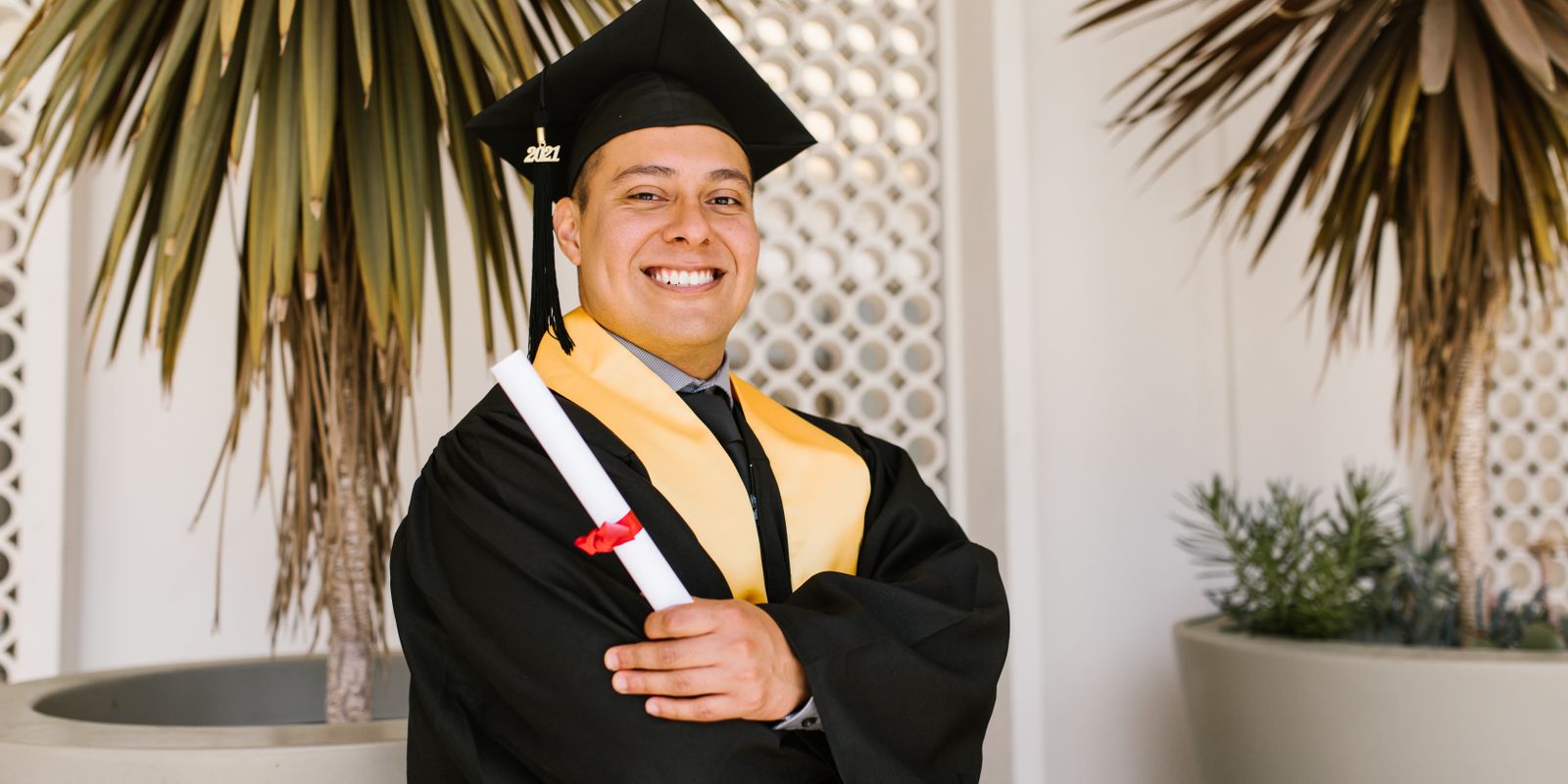 A joyful graduate holding a diploma, symbolizing success and accomplishment.