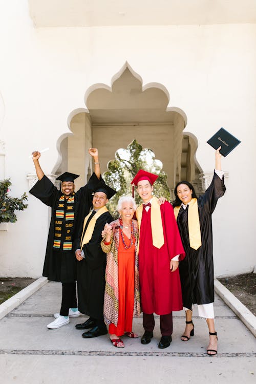 Free Newly Graduate Students Posing with Their Hands Raised  Stock Photo