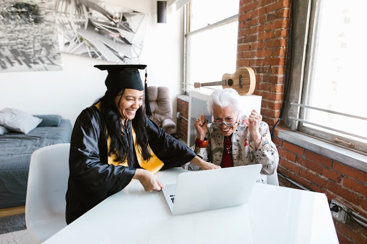 Elderly Woman Watching The Virtual Graduation With The Student 