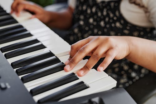 Free A Close-up Photography of a Young Person Playing the Piano Stock Photo