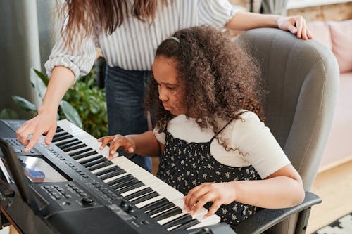 Free Person Teaching the Girl How to Play a Piano  Stock Photo