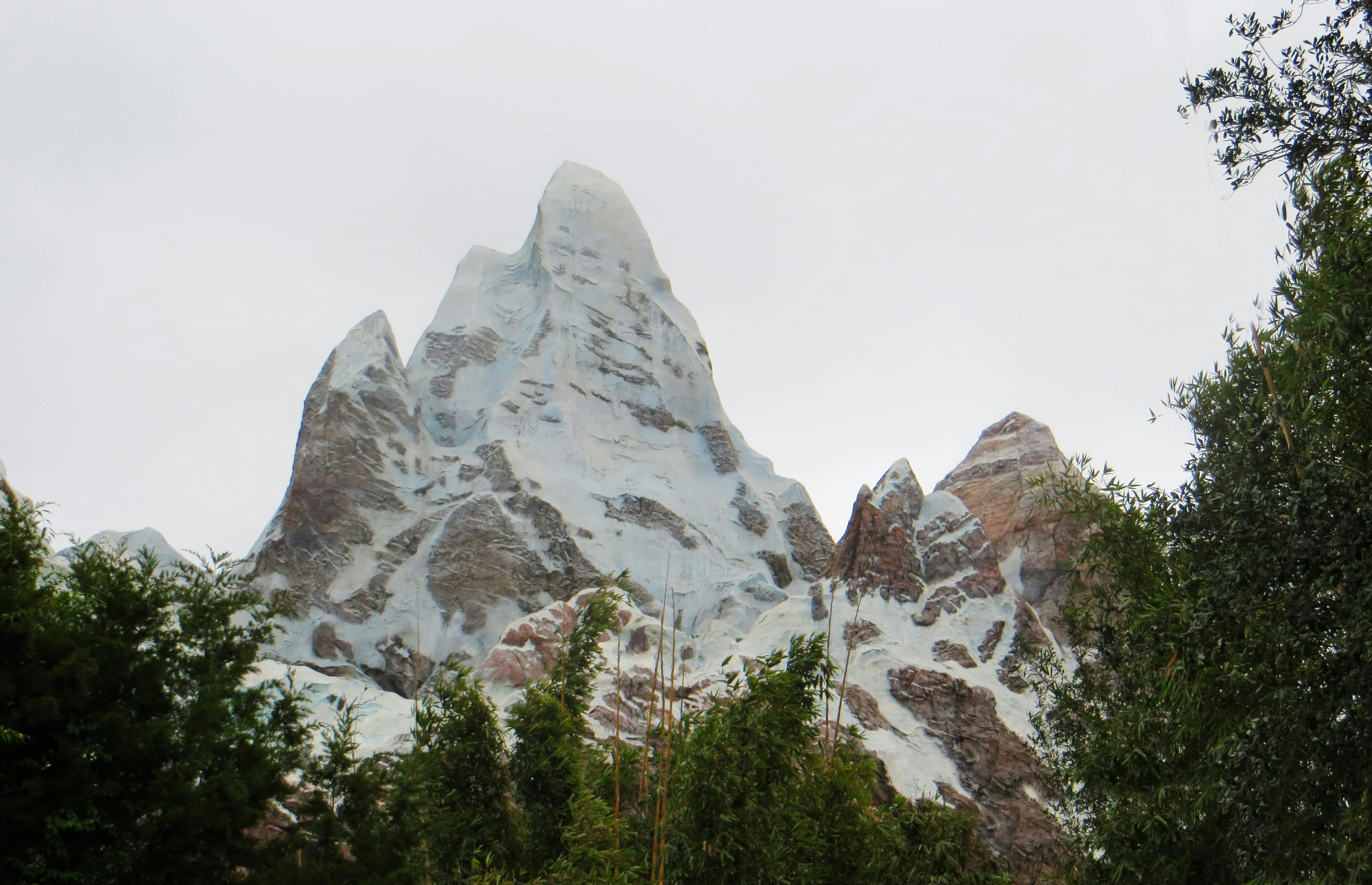 晴朗的天空下，风景秀丽的山峰被郁郁葱葱的绿树包围