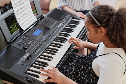 African American girl playing the keyboard indoors, practicing music.