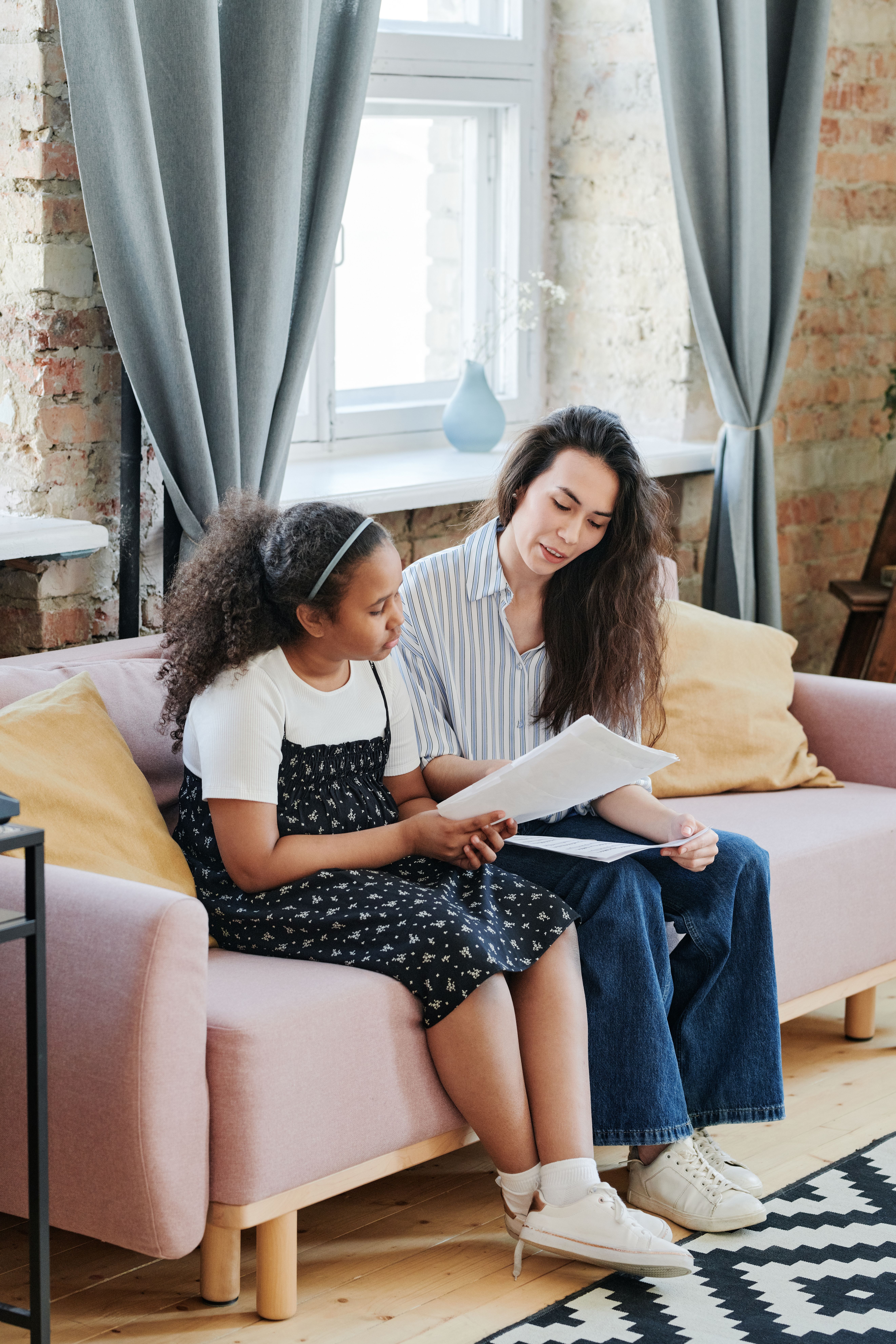 A parent and child sitting together on a couch reviewing documents, the kind of coverage-checking conversation worth having before a back-to-school dental visit